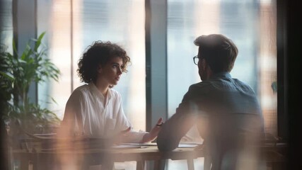 Professional colleagues having serious business discussion during meeting in modern office