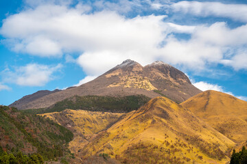 Autumn leaves hillsides around Mt. Aso close to Nakadake Crater with views on the cone of Komezuka crater and other peaks, Kumamoto, Japan