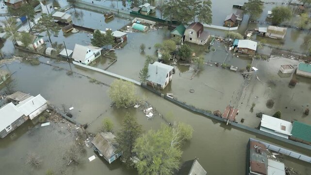Aerial drone footage of a massive city flood with houses and streets submerged under water. Urban flooding caused by extreme weather and heavy rainfall, showing natural disaster impact on residential 