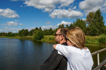 Fototapeta premium A happy couple. The couple's summer walk across the bridge: the concept of outdoor activities and romance.
