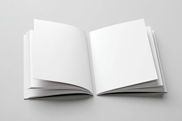 Open book with blank white pages spread on light grey surface