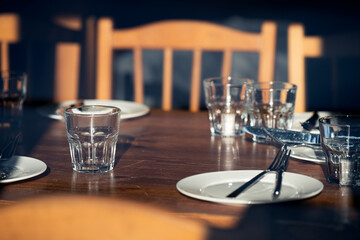 Setting the festive table.  Empty  glasses and plates on wooden table