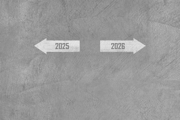 year transition 2025 to 2026 with white arrow paint on grey concrete floor