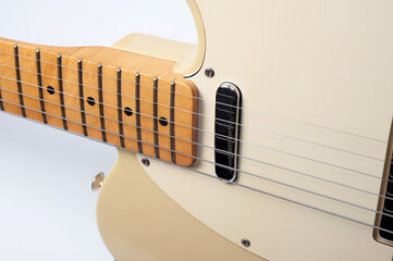 Six-string electric guitar, with a cream-colored wooden body and chrome-plated fittings.