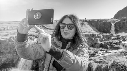 Group of travelers visiting Kirkjufell waterfalls Iceland surrounded by mountains and greenery