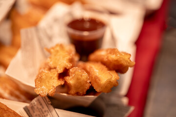 Churros served in a paper cone with a side of rich chocolate, ready for dipping and enjoying