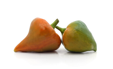 Two small raw pimiento peppers on a white background.