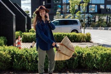 Woman with bag talking on phone outside