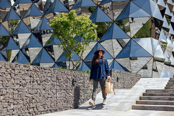 Woman walks near reflective building in city area