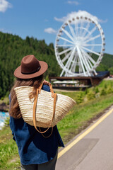 Woman walks near a large wheel on a sunny day