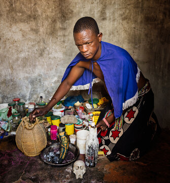 African Sangoma traditional healer performing a ritual with medicinal herbs and bones, honoring ancestor beliefs and ancient spirituality