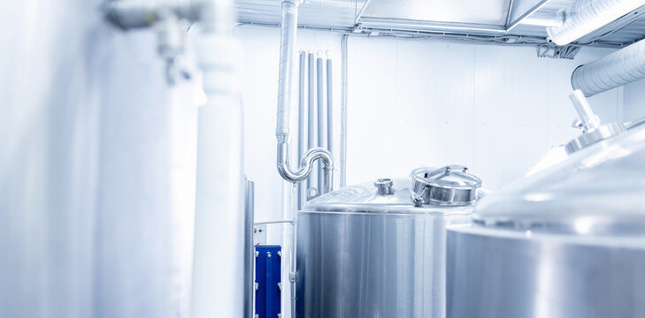 Industrial brewery equipment and stainless steel tanks in modern beer factory banner