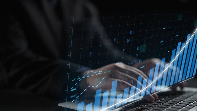 Professional businessman analyzes financial data on a laptop, with digital graphs illustrating growth trends and key performance metrics in a modern office setting. Copula - Powered by Adobe
