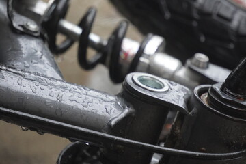 Close up of a wet motorcycle suspension system.