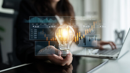 A business professional holds a light bulb, representing innovative ideas, while analyzing...
