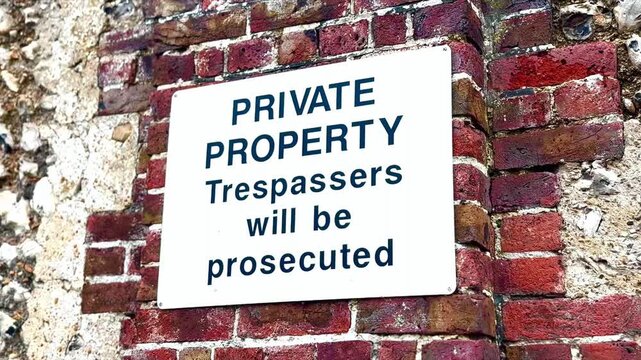 private property trespassers will be prosecuted white sign on brick wall