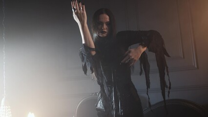 Gothic fashion portrait showing a femme fatale in black godet dress with corset, featuring long straight hair, dark makeup, and set in an opulent dark interior.