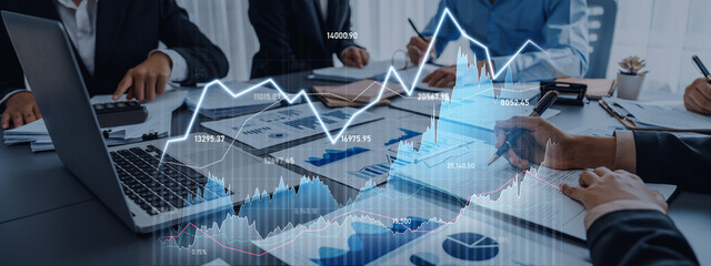 A dynamic scene of business professionals analyzing financial data with graphs displayed on a laptop. The collaborative environment fosters strategic discussions and decision making. Scalp