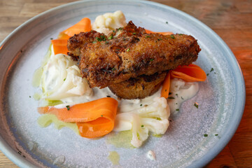 A panko encrusted soft shell crap atop a crab and potato rositi, with picked vegetables and creme fraiche dressing
