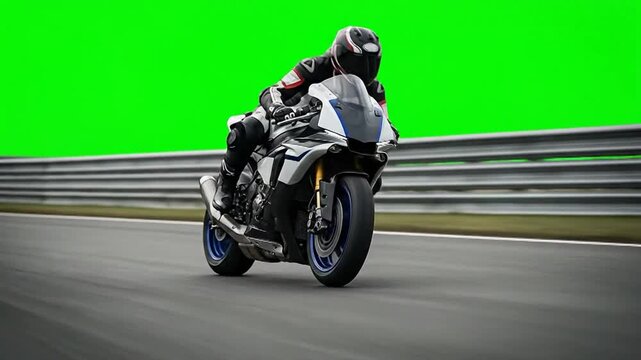 A professional racer expertly leans a sport motorcycle into a sharp turn on a race track against a bright green screen backdrop