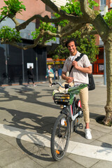 Indian man standing with bicycle, carrying reusable shopping in urban setting, promoting sustainable lifestyle and green transport
