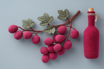 Crocheted bunches of red wine grapes and bottle of wine in crocheted cover.	
