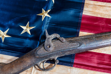 old musket on tea stained Betsy Ross American flag