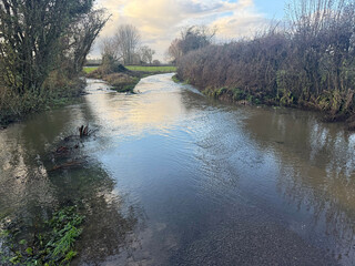 Flooded lane  caused by stream which has burst its banks in winter after heavy rain, East Chinnock, Somerset, UK