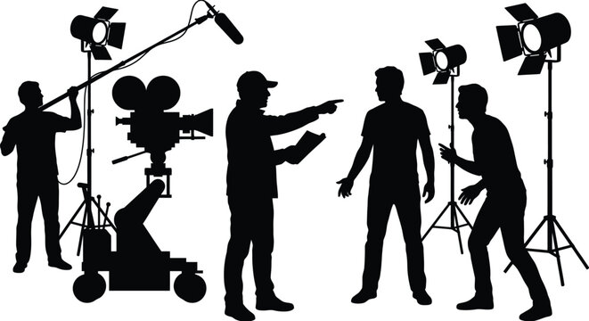 Silhouette of professional film director pointing finger while instructing actors on movie set with camera crew and boom operator recording sound under spotlights.