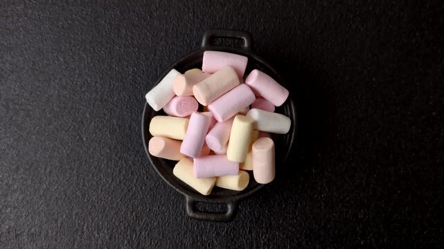 Mini marshmallows in white, pink, and pastel colors, a colorful Christmas dessert. Marshmallows as a food background for your design