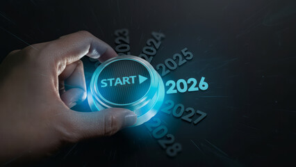 Hand pressing start button with glowing blue light on black background