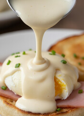 a breakfast dish featuring a poached egg smothered in creamy white sauce