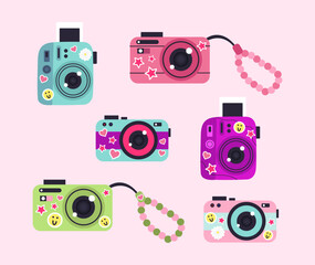 Illustration of cute cameras with stickers on a light pink background.