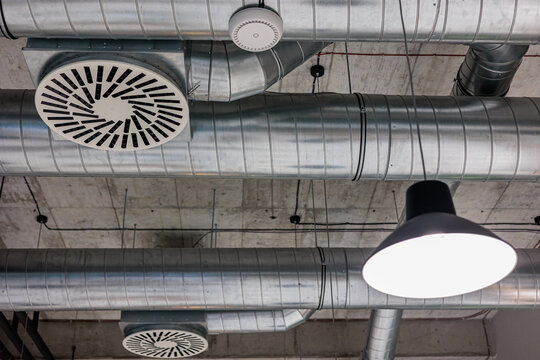Industrial air circulation system in a modern building with ductwork and lighting fixtures