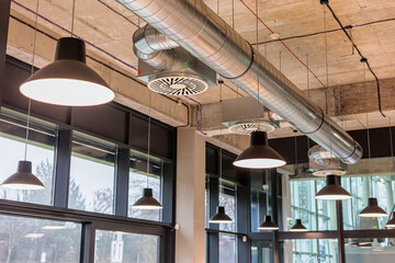 Industrial air circulation system in a modern building with ductwork and lighting fixtures