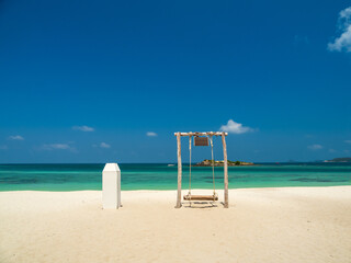Peaceful panorama tropical sea beach with gentle waves rolling onto golden sand under bright blue sky with fluffy white clouds. relaxing summer scene perfect scene for travel holliday and nature lover