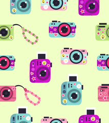 Pattern of cameras with stickers on a light green background.