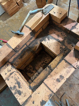 Fresh brickwork of the ash pit and firebox of a heating stove. Oblique Angle.