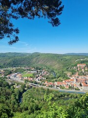 Panoramic viewpoint over Bardo Śląskie and the Kłodzko Valley. Green hills, the Nysa Kłodzka River and a small town create a peaceful landscape of southern Poland.