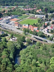 Panoramic viewpoint over Bardo Śląskie and the Kłodzko Valley. Green hills, the Nysa Kłodzka River and a small town create a peaceful landscape of southern Poland.