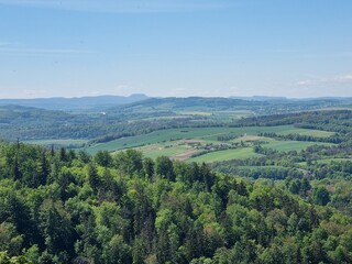 Panoramic viewpoint over Bardo Śląskie and the Kłodzko Valley. Green hills, the Nysa Kłodzka River and a small town create a peaceful landscape of southern Poland.
