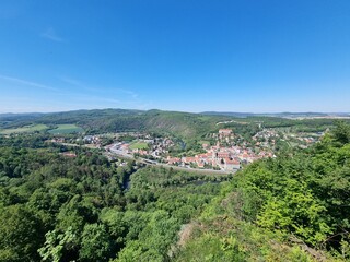 Panoramic viewpoint over Bardo Śląskie and the Kłodzko Valley. Green hills, the Nysa Kłodzka River and a small town create a peaceful landscape of southern Poland.