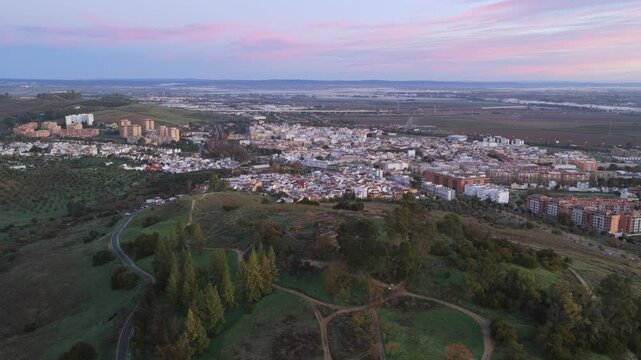 Aerial view of El Carambolo hill with Camas town in background, blending archaeology, landscape, and urban surroundings.