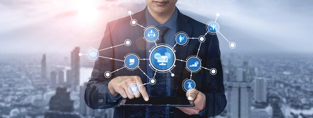 A professional businessman interacts with a tablet, surrounded by digital icons representing technology and data networking against an urban backdrop. Tessel