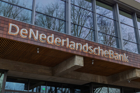 Close up low angle view of the De Nederlandsche Bank signage attached to the brown brick facade of the Dutch Central Bank headquarters. Amsterdam Netherlands, 28 december 2025