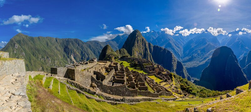 Machu Picchu city high resolution panorama. Andes terraces ancient structures stand on a mountain ridge at Machu Picchu surrounded by steep green slopes historical Inca architecture tourist sight Peru