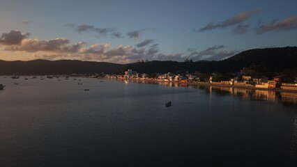 A serene coastal town at dusk with calm waters and distant mountains