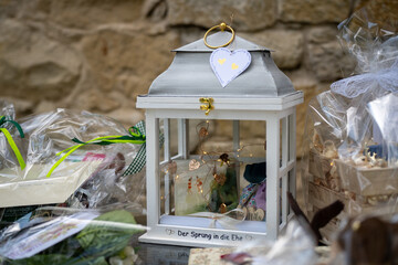 Ein Hochzeitsgeschenk, eine Laterne aus Glas und Holz mit Dekoration und der Aufschrift 