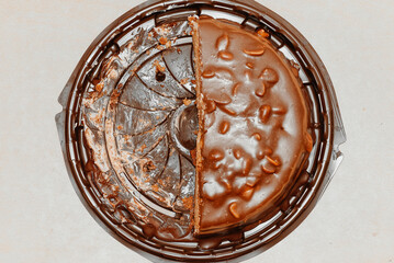 large brown sliced chocolate cake with cream and peanuts, sweet tasty food for holydays and celebrating, half eaten, selective focus