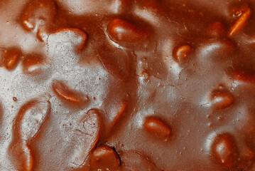 large brown sliced chocolate cake with cream and peanuts, sweet tasty food for holydays and celebrating